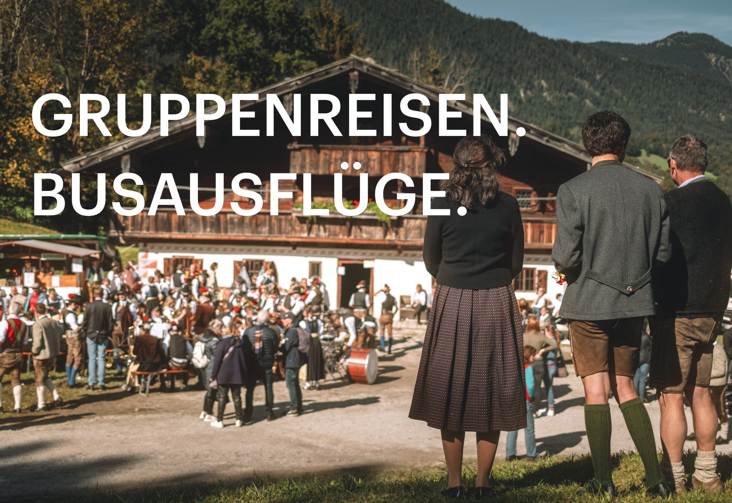 Drei Personen in Tracht stehen vor dem Walchseehof am Kirchtag